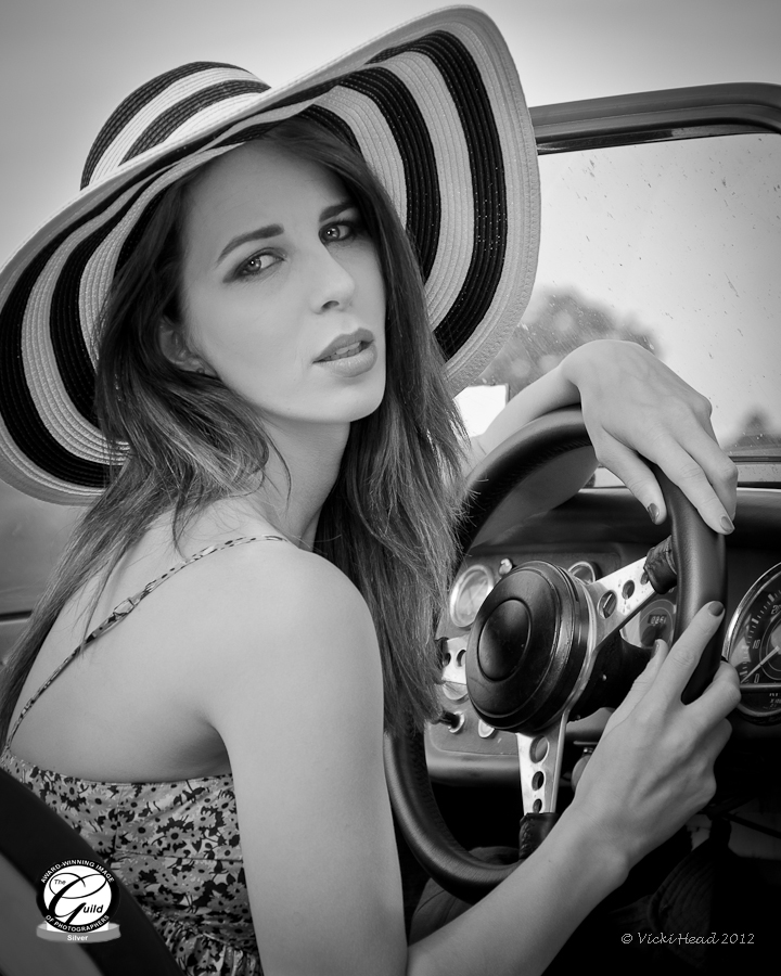 Black and white photograph of girl in a sports car